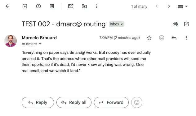 A test email addressed to dmarc, subject TEST 002 - dmarc@ routing, received in Gmail and labeled Inbox at 7:06 PM. The body quotes the line read on camera before sending it, and the Gmail toolbar is visible at the top.